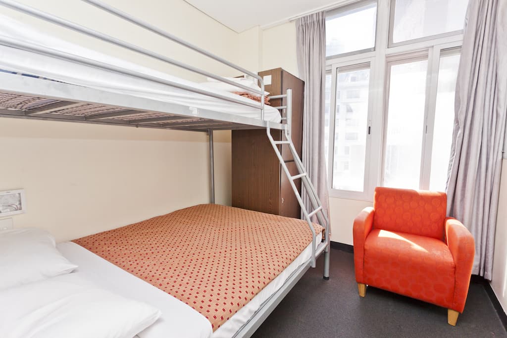 Private double/triple room at 790 on George with bunk bed and orange armchair